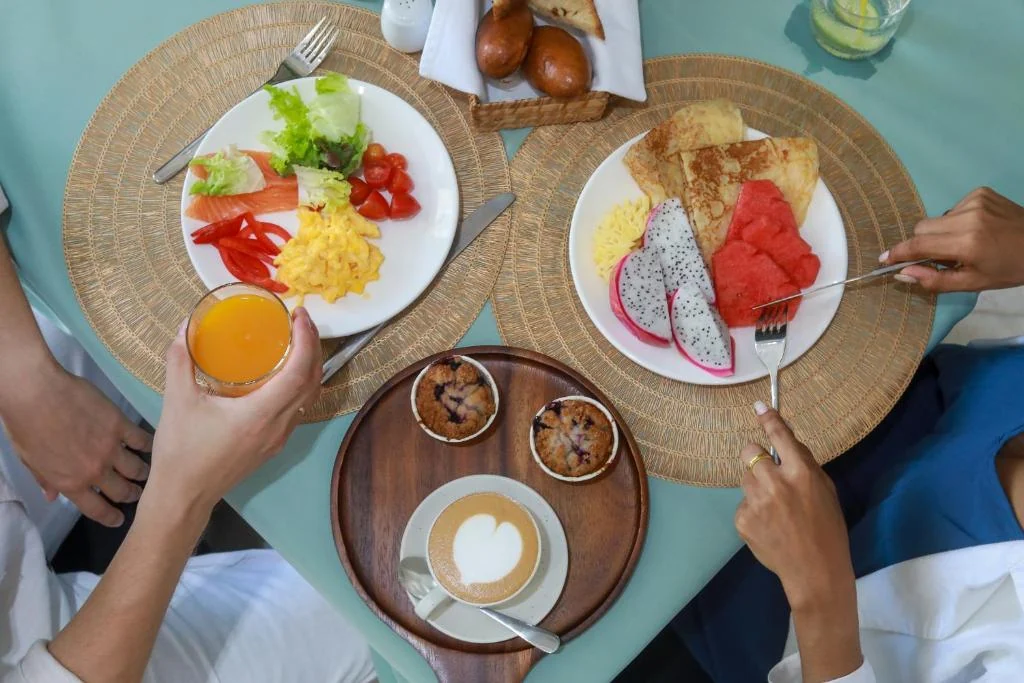 Breakfast plates with fruit, eggs, pastries, coffee and juice at Andaman Riviera